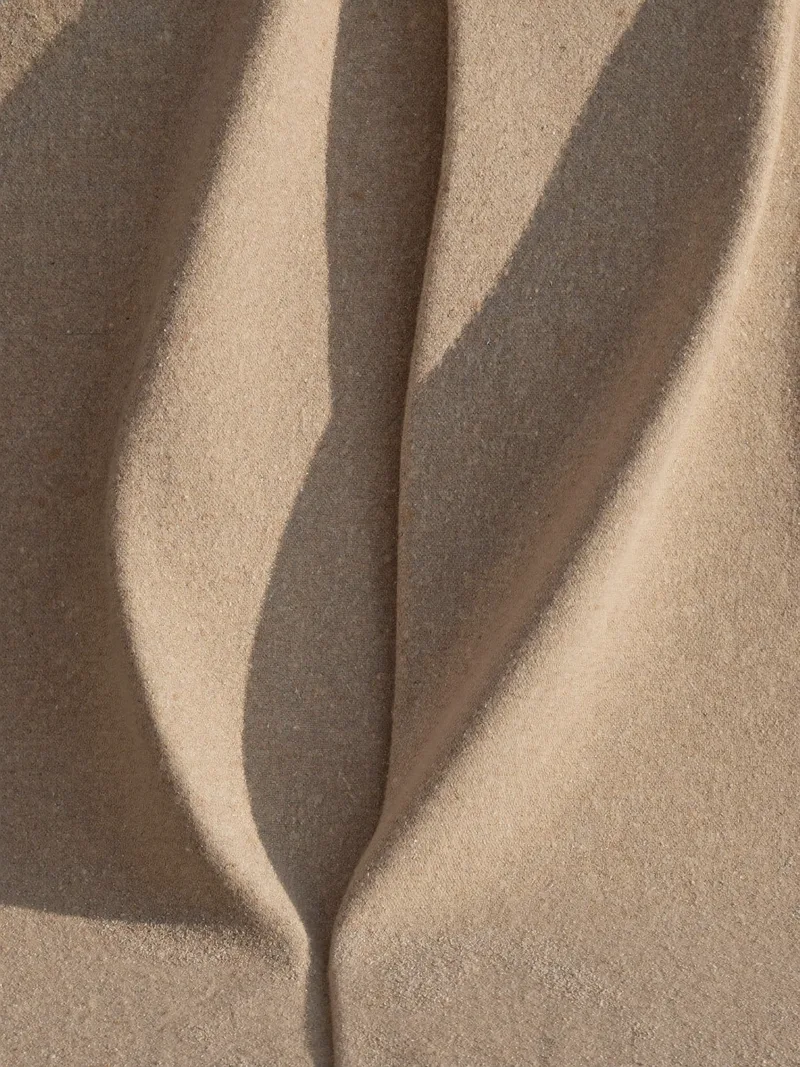 Heavy wool zibeline thermoformed into two standing waves, sand dusted in the trough