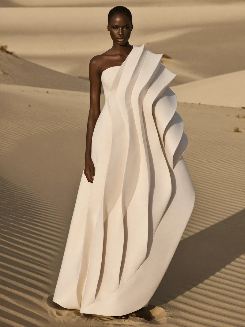 Look II, Crête — strapless gown in bone wool zibeline with five standing sculpted waves, photographed among rippled dunes